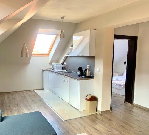 uma cozinha com armários brancos e um lavatório num quarto em ,,Адела”-апартамент за гости em Velingrad