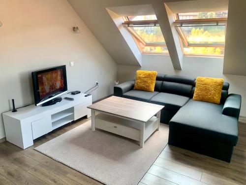 uma sala de estar com um sofá e uma televisão em ,,Адела”-апартамент за гости em Velingrad