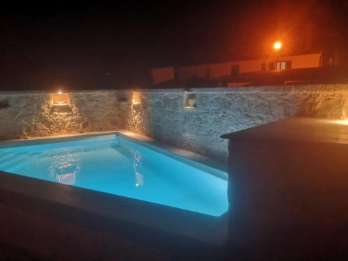 una piscina iluminada por la noche con luces en Casa Ladonja, en Poreč