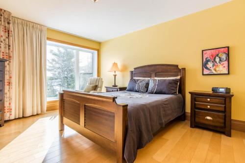 a bedroom with a large bed and a window at Au Sommet du Lac Magog in Magog-Orford
