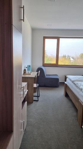 a hotel room with a bed and a desk and a window at Pension Vinařství Klučov in Klučov