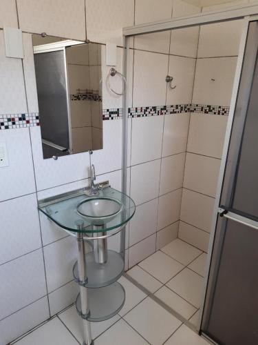 a bathroom with a glass sink and a shower at Casa para temporada - Chapada das Mesas in Carolina