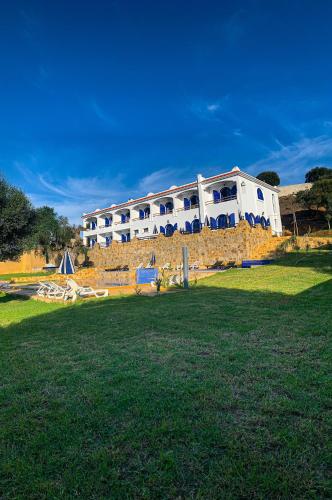 a large white building on top of a stone wall at Dmina House in Asilah