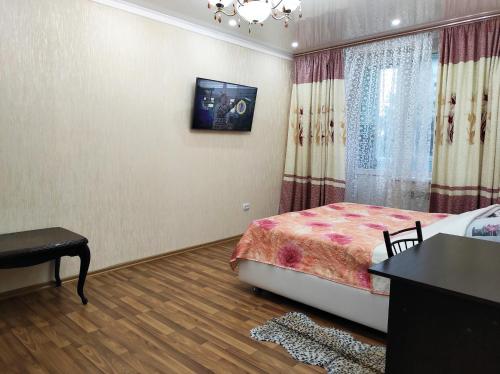 a bedroom with a bed and a table and a window at Apartment on Suvorova in Bender