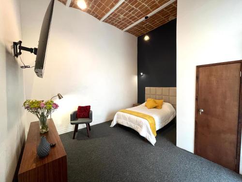 ein Schlafzimmer mit einem Bett und einem Stuhl in einem Zimmer in der Unterkunft Casa Mazonce in Mexiko-Stadt