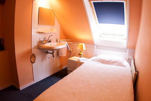 a small bathroom with a bed and a sink at B&B De Oude Molensteen in Eelde-Paterswolde