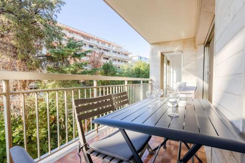 d'un balcon avec une table et des chaises bleues. dans l'établissement Renovated 3-Room Apartment in a Leafy Park, à Cannes