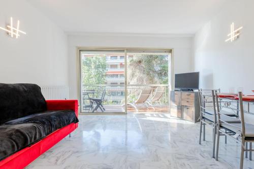 un salon avec un canapé rouge et une table dans l'établissement Renovated 3-Room Apartment in a Leafy Park, à Cannes