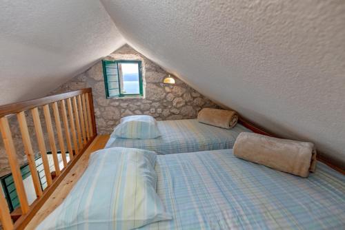 two twin beds in a room with a staircase at stone house Nikolina with heated Pool in Bast