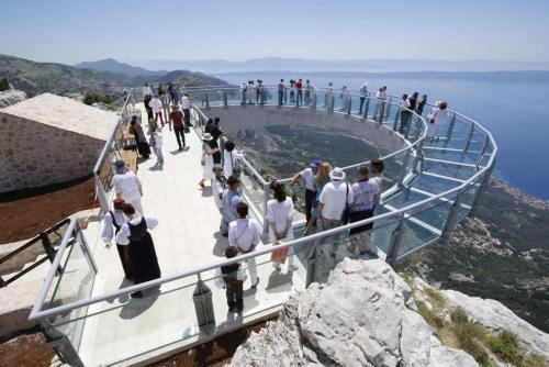 people on a viewing platform at the top of a mountain at stone house Nikolina with heated Pool in Bast
