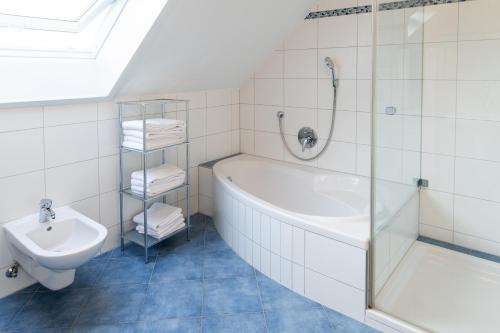 a bathroom with a shower and a tub and a sink at Ferienwohnung Ella in Meckenbeuren
