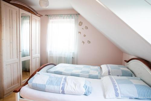 a bedroom with two beds and a window at Ferienwohnung Ella in Meckenbeuren