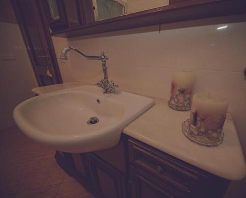 a bathroom with a sink and two candles on the counter at Cassiodoro Rooms Affittacamere in Catanzaro