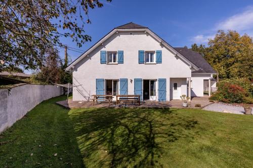 a white house with blue windows and a fence at Les 3 Edelweiss - GITE 1 OU GITE 2 in Arette
