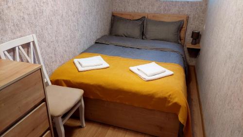 ein kleines Schlafzimmer mit einem Bett mit zwei Handtüchern darauf in der Unterkunft Yellow Apartment in Tbilisi City