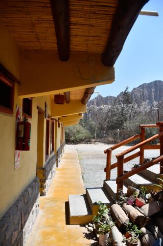 a porch of a building with benches on it at Tilcara Rustica Hostel in Tilcara