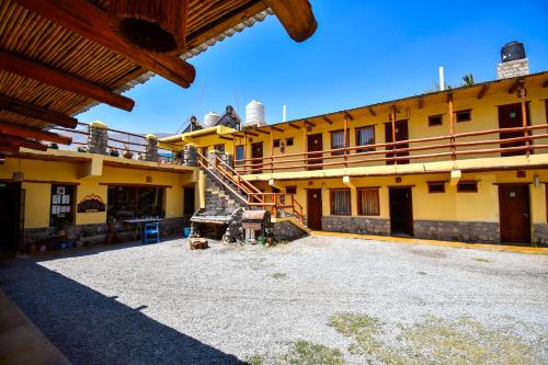 a large yellow building with a staircase on it at Tilcara Rustica Hostel in Tilcara
