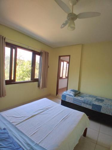 a bedroom with two beds and a ceiling fan at Antakarana Hospedagem in Lençóis