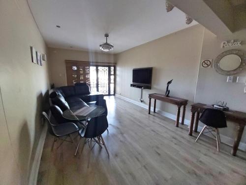 ein Wohnzimmer mit einem Sofa und einem Tisch in der Unterkunft Whale Rock, Modern Beachfront Apartment in Margate