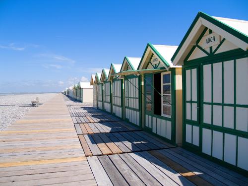 a row of buildings on a boardwalk on the beach at " Tchio Batteux" les Gîtes de Sery in Bouillancourt-en-Séry
