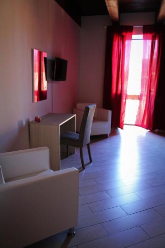 a living room with red curtains and a table and chairs at B & B Arcobaleno in Cosenza