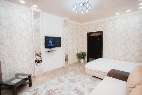 マイコープにあるApartment Sovetskaya 184のベッドルーム1室(ベッド1台、壁にテレビ付)