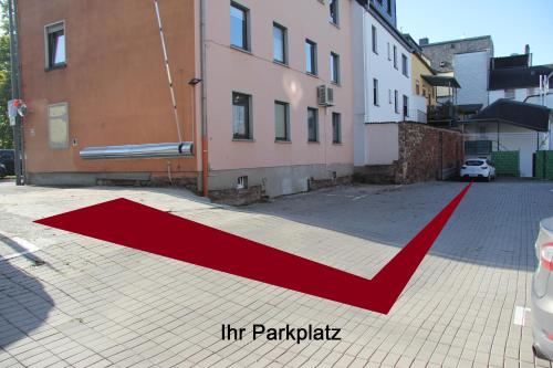 a red arrow on a street next to buildings at Gemütliche City Wohnung - Im Herzen von Trier in Trier