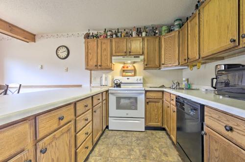 a kitchen with wooden cabinets and a white stove top oven at Upson Ski-InandSki-Out, End-Unit Cabin with Fireplace! in Montreal
