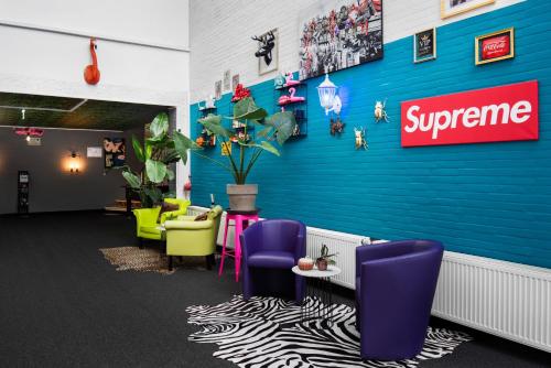 a waiting room with purple chairs and a blue wall at SmartHotel Flamingo Self check-in in Gießen
