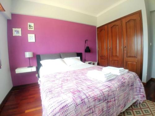 a bedroom with a bed with a purple wall at Be Local - Apartment with 3 bedroom near Oriente Station in Lisbon in Lisbon