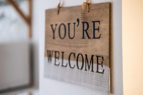 a sign that says youre welcome hanging on a wall at Le gîte de Maillebois in Maillebois