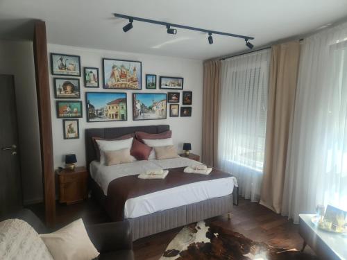 1 dormitorio con 1 cama con cuadros en la pared en Tuzla Trg - Tuzla Square en Tuzla