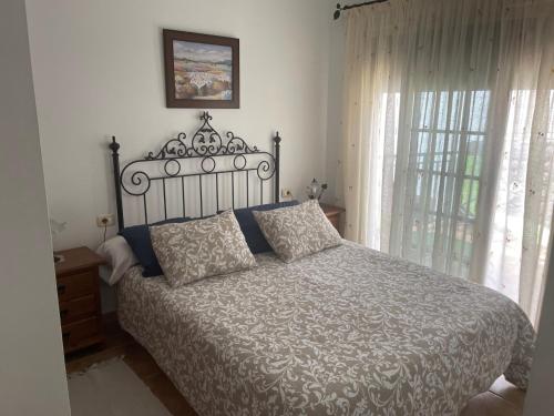 a bedroom with a bed and a window with curtains at El Hoyo in Frontera