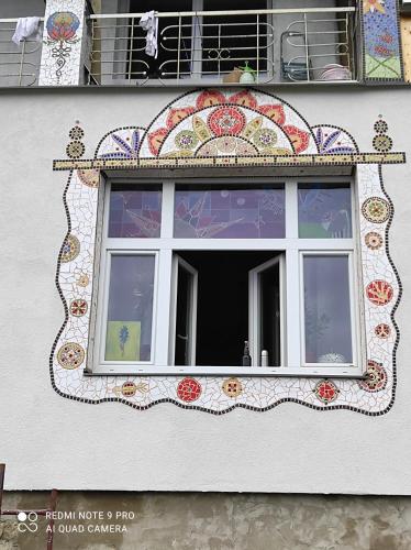 una ventana con un diseño de mosaico en el lateral de un edificio en art-house 4 Attic Apartment en Děčín