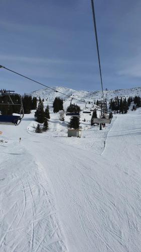 a ski slope with a ski lift in the snow at Hotel PlannerInn in Planneralm