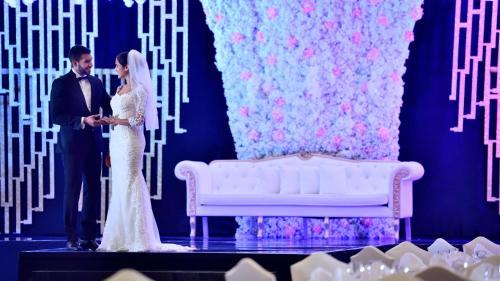 a bride and groom standing next to a white couch at InterContinental Abu Dhabi by IHG in Abu Dhabi