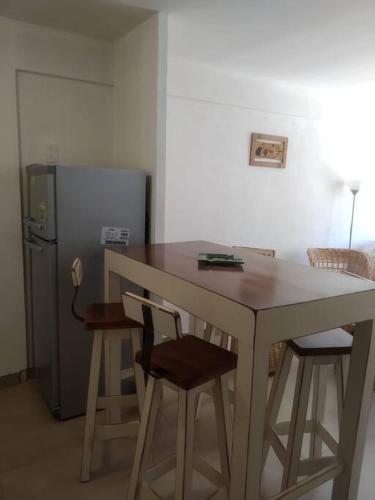 La cuisine est équipée d'une table, de chaises et d'un réfrigérateur. dans l'établissement Departamento Albarracin, à San Carlos de Bariloche