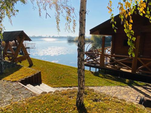 a log cabin with a view of a lake at Домик у озера с мангалом и террасой in Kyiv