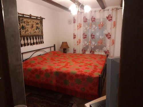 a bedroom with a bed with a red comforter at Apartment museum in Kobern-Gondorf
