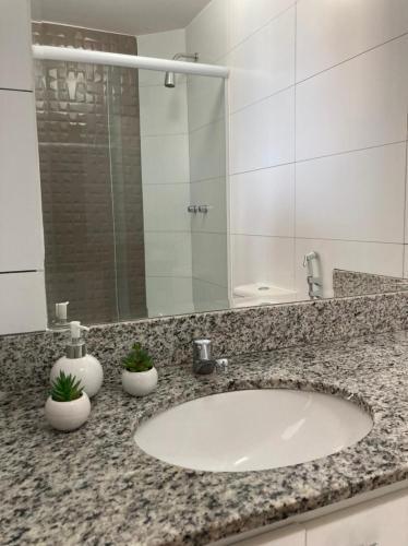 a bathroom counter with a sink and a mirror at Porto Real Suites Resort in Mangaratiba