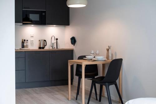 a small kitchen with a table and two chairs at HOOM HOME & HOTEL Sigtuna in Rosersberg
