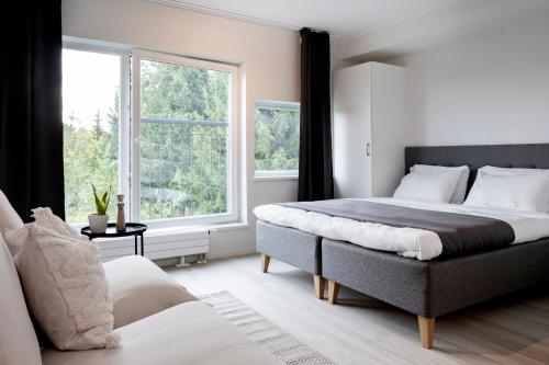 a bedroom with two beds and a large window at HOOM HOME & HOTEL Sigtuna in Rosersberg