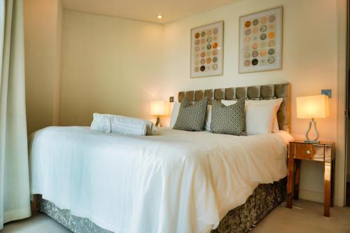 um quarto com uma grande cama branca e 2 candeeiros em GWQ Apartments Luxe em Portsmouth