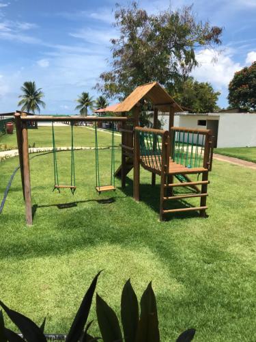 a park with a swing and a gazebo at Catamaran Praia Chalés in Igarassu