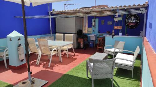 a patio with a table and chairs in a room at Casa Marenga El Palo in Málaga