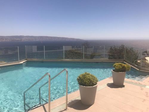 a large swimming pool with a view of the ocean at Depto. estudio con vista al mar in Viña del Mar