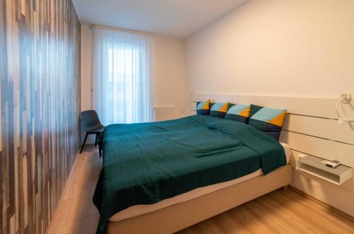 a bedroom with a green bed and a window at Balatoni Apartman in Fonyód