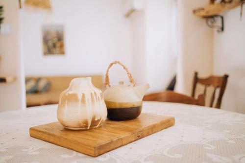 two vases sitting on a cutting board on a table at סלעית 8 in Mitzpe Ramon