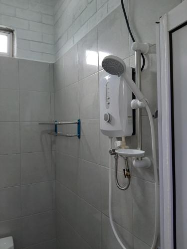 La salle de bains est pourvue d'une douche avec un pommeau de douche. dans l'établissement GekQ Inn Langkawi B, à Pantai Cenang