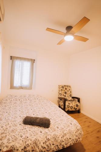 a bedroom with a bed and a ceiling fan and a chair at סלעית 8 in Mitzpe Ramon